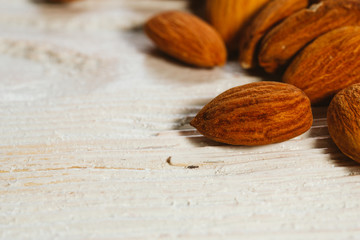 handful of almonds on a white wooden background
