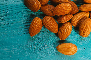 handful of almonds on a blue wooden background