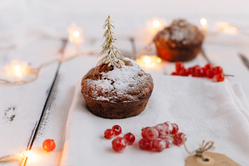 Christmas Muffin Dusted with Icing Sugar and topped with Gold Christmas Tree Decoration on Shabby Chic Table