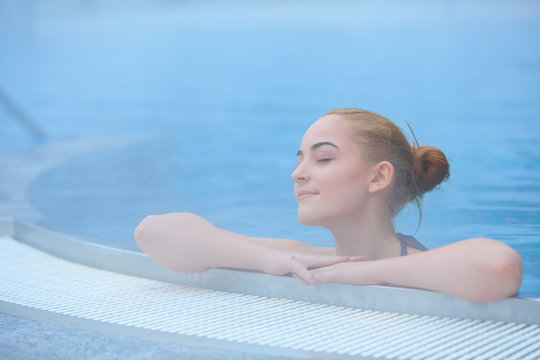 Young woman in outside thermal pool, relaxed