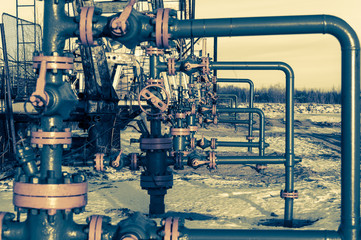 Group of wellhead. Oilfield with sand ground. Oil and gas . Toned.