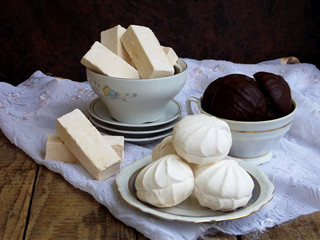 Sweet white Russian marshmallow, chocolate zephyr, meringue, apple pastila on wooden background. Selective focus