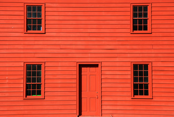 Four windows and door on red home