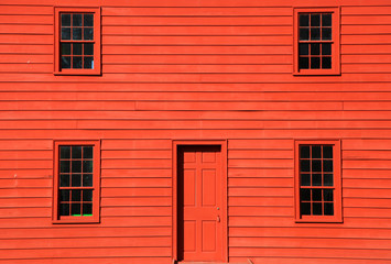 Four windows and door on red home