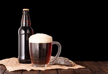 dark cold beer in a frosty mug, stockfish, brown bottle on dark