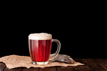dark cold beer in a frosty mug on dark wooden table