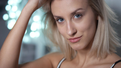 Portrait of playful attractive young woman over shining background.
