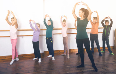 Fototapeta na wymiar diligent boys and girls rehearsing ballet dance in studio