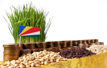 Seychelles flag waving with stack of money coins and piles of wheat