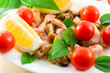 Mussels, squid and octopus, decorated with greens, cherry and le