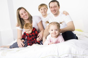 five member Young Family Having Fun In Bed