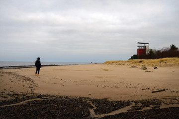 man standing on a beach in cloudy weather