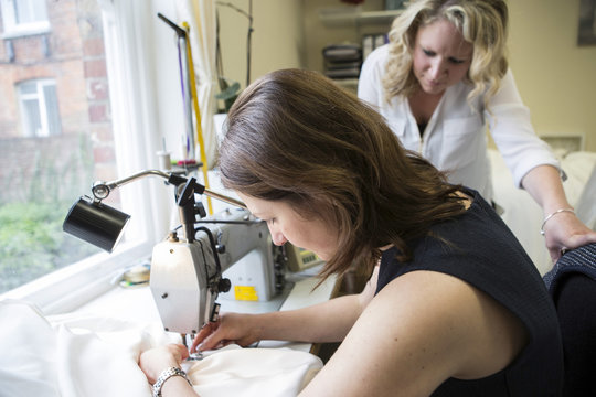 Women working at sewing machine in bridal shop