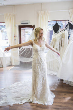 Female customer in bridal shop trying on wedding dress