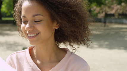 Close up of a young african american woman smiling to a camera.