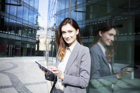 Portrait of businesswoman using digital tablet while standing