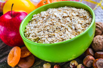 Oatmeal or oat flakes on dark wooden table
