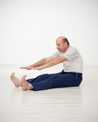 Fototapeta na wymiar Elderly man practicing yoga or fitness. Positive mood on sports activities