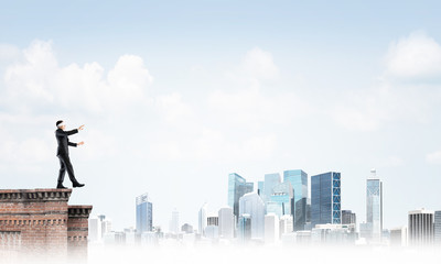 Danger and risk concept with businessman making step from edge