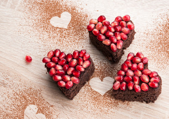 Heart shaped brownie cake with pomegranate seeds - Valentines day food background, blank space for recipe text or wedding invitation