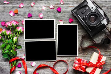 vintage retro camera with blank photo frames and pink roses