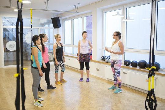 Fitness instructor in health club explains suspension training