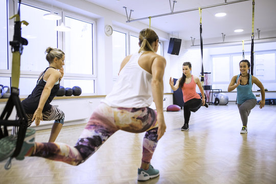 Women in exercise class doing suspension training
