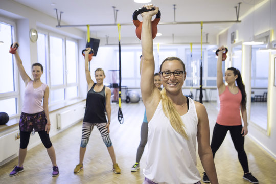 Women in exercise class lifting kettlebells