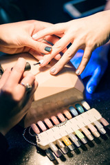 Manicurist putting shellac on the fingernails in beauty salon