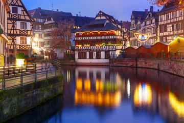 Traditional Alsatian half-timbered houses with mirror reflections in Petite France during twilight blue hour, Strasbourg, Alsace, France