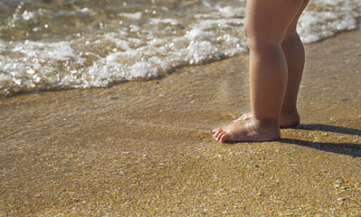 Close up of a baby's legs at the beach