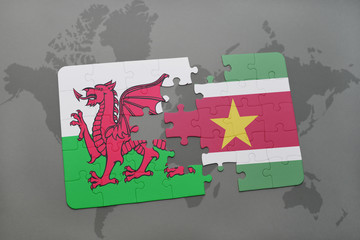 puzzle with the national flag of wales and suriname on a world map