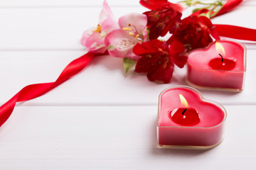 Two heart shape candles and flowers