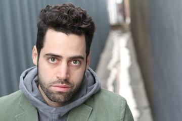 Obraz premium Portrait of young man against empty urban alley way - Stock image