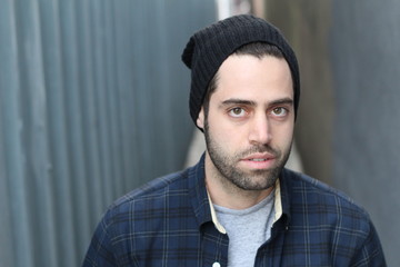 Portrait of young man against empty urban alley way - Stock image