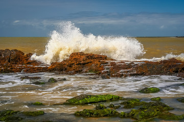 Strong wave hitting rocks on the beach