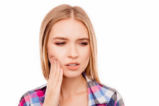 Sad ill woman having toothache and touching cheek
