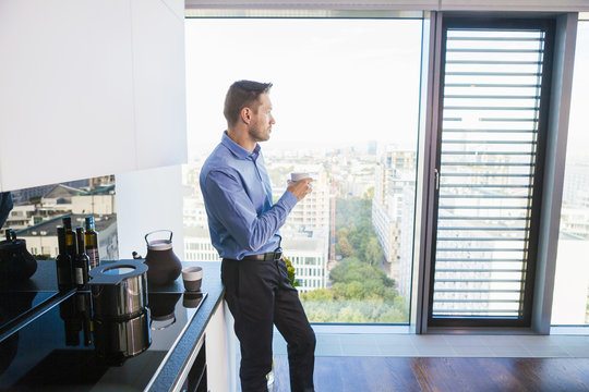 Businessman in apartment having a coffee break