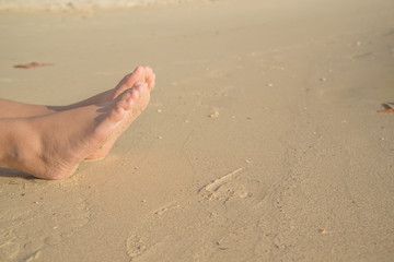 feets with sand of lady sit on the beach
