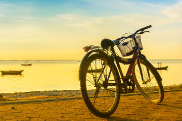 Obraz premium Ride a bicycle on beach with warm light background