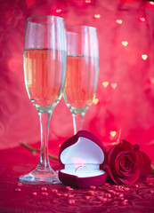 Romantic setup with champagne, rose and engagement ring 