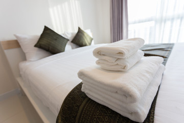 Fototapeta na wymiar White towel on bed decoration in bedroom interior