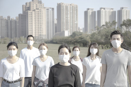 Young Group Wearing Mouth Mask Against Air Pollution In City