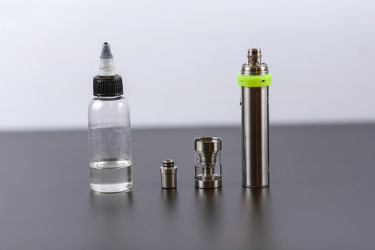 Parts of e-cigarette and a jar with fluid for personal vaporisers. Electronic nicotine delivery systems (ENDS). Jar with fluid.