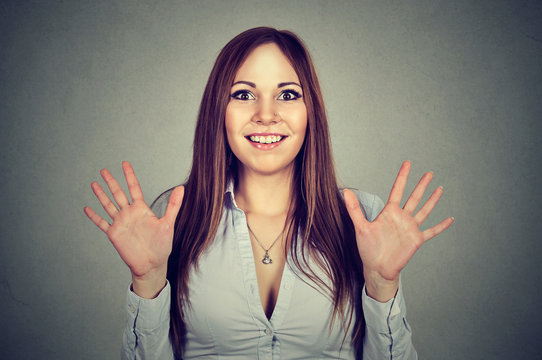 excited woman with hands up near her face smiling