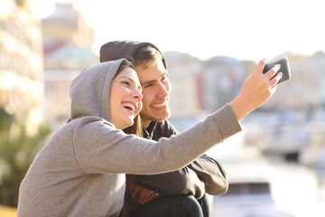 Couple of teens taking a selfie outdoors