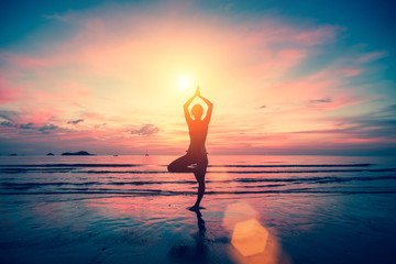 Silhouette yoga girl on the background of stunning sea and sunset. Fitness, meditation and healthy...