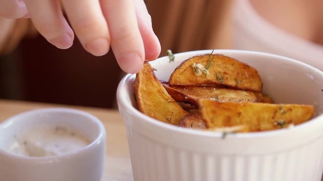 SLOW MOTION: young caucasian girl eats fresh fried potatoes