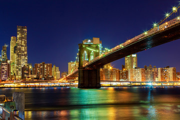Naklejka premium Most Brookliński o zmierzchu widziany z parku w Nowym Jorku.