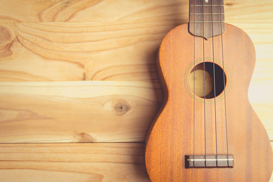 Close up of ukulele on old wooden background , vintage